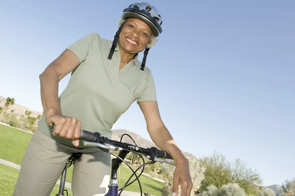 Femme âgée assis sur le vélo de montagne — Photo