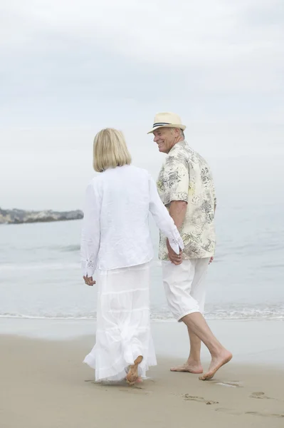 Pareja cogida de la mano mientras camina en la playa —  Fotos de Stock