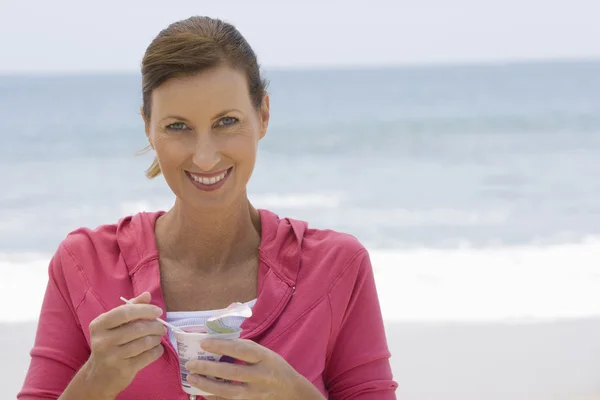 Mooie vrouw yoghurt gelet op strand — Stockfoto