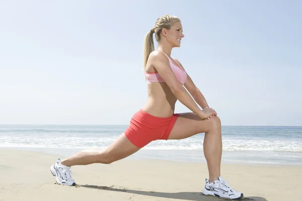 Kobieta robi ćwiczeń fitness na plaży — Zdjęcie stockowe