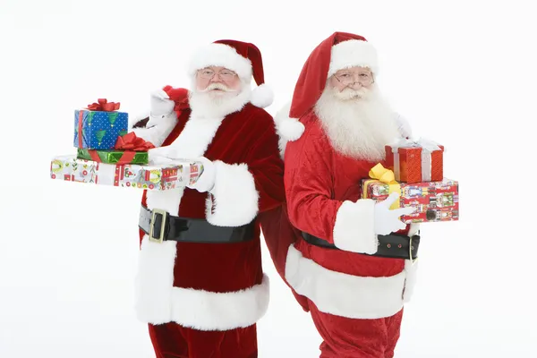 Homens em trajes de Papai Noel em pé com presentes — Fotografia de Stock