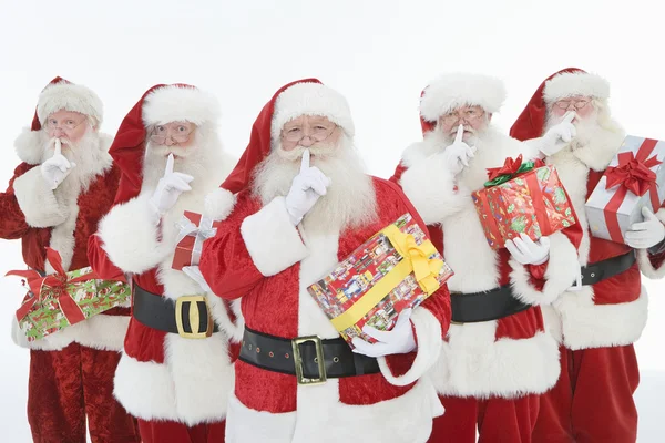 Skupina mužů oblečený jako santa claus drží dary — Stock fotografie