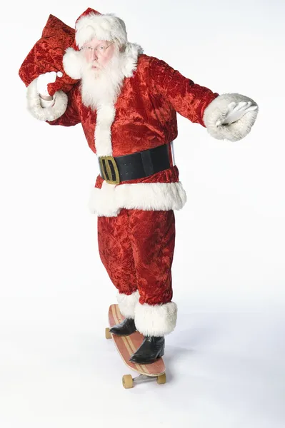 Santa claus na skateboard s pytlem — Stock fotografie