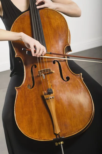 Donna inchinando un violoncello — Foto Stock