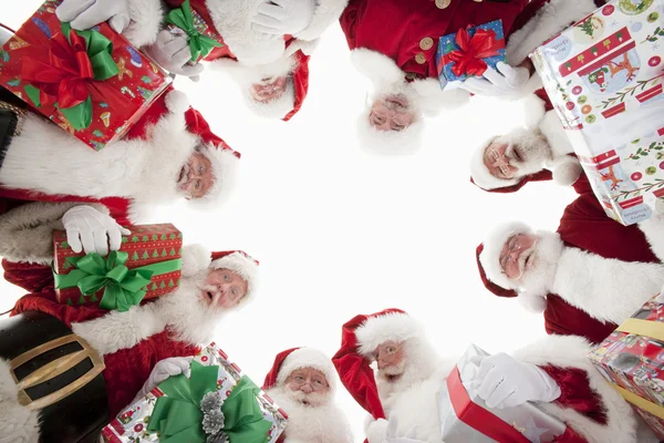 Homens em trajes de Papai Noel formando Huddle — Fotografia de Stock