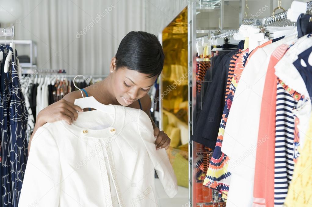 Woman Considers White Jacket In Clothes Store