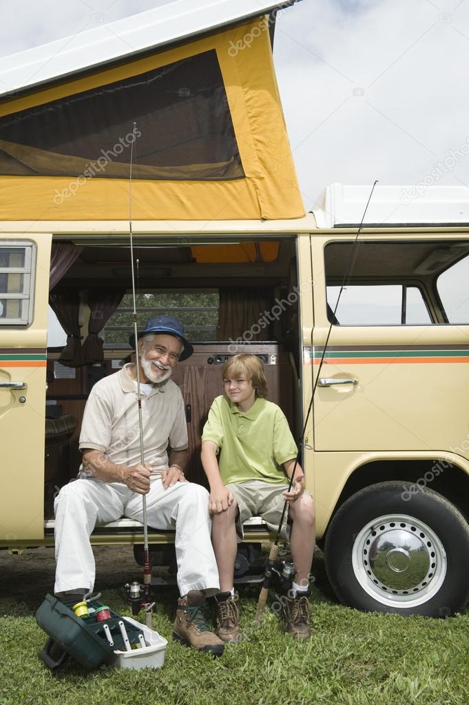 Grandfather And Grandson With Fishing Rods In Campervan