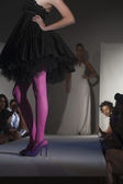 Model In Pink Tights And Black Dress On Fashion Catwalk
