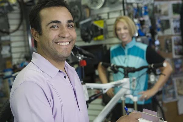 Fiets shop assistent met wielrenster — Stockfoto