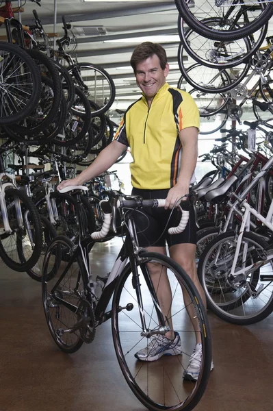 Hombre de pie con bicicleta en la tienda —  Fotos de Stock