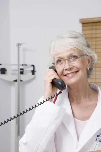 Médico femenino usando teléfono en la clínica —  Fotos de Stock