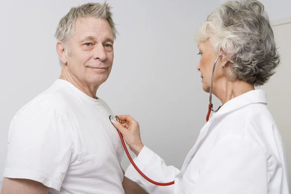 Arzt überprüft Patientin mit Stethoskop — Stockfoto