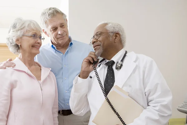 Médecin regardant les patients tout en utilisant le téléphone fixe — Photo