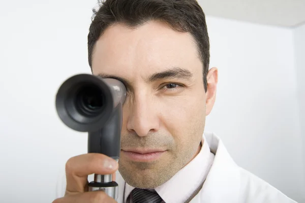 Médecin masculin regardant à travers l'ophtalmoscope — Photo