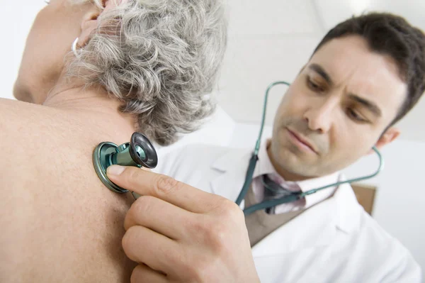 Médico revisando la espalda del paciente usando estetoscopio — Foto de Stock