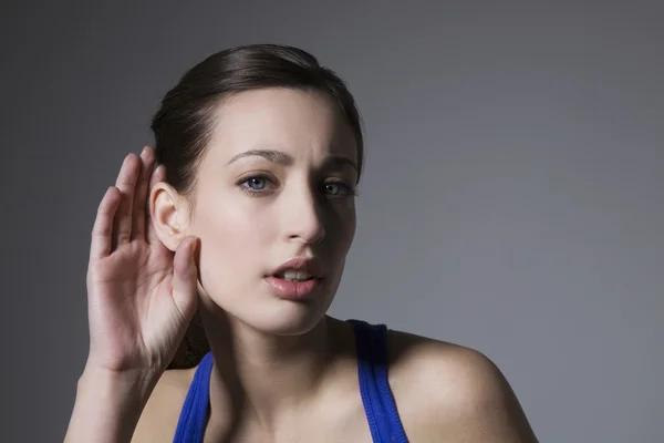 Jonge vrouw met hand achter oor — Stockfoto