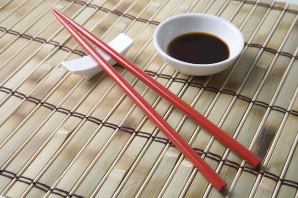 Soy Sauce With Chopsticks On Mat — Stock Photo, Image