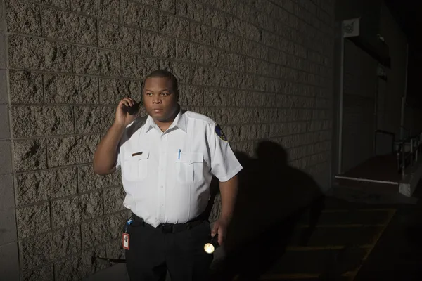 Guardia de seguridad con walkie talkie y antorcha patrullas en la noche — Foto de Stock
