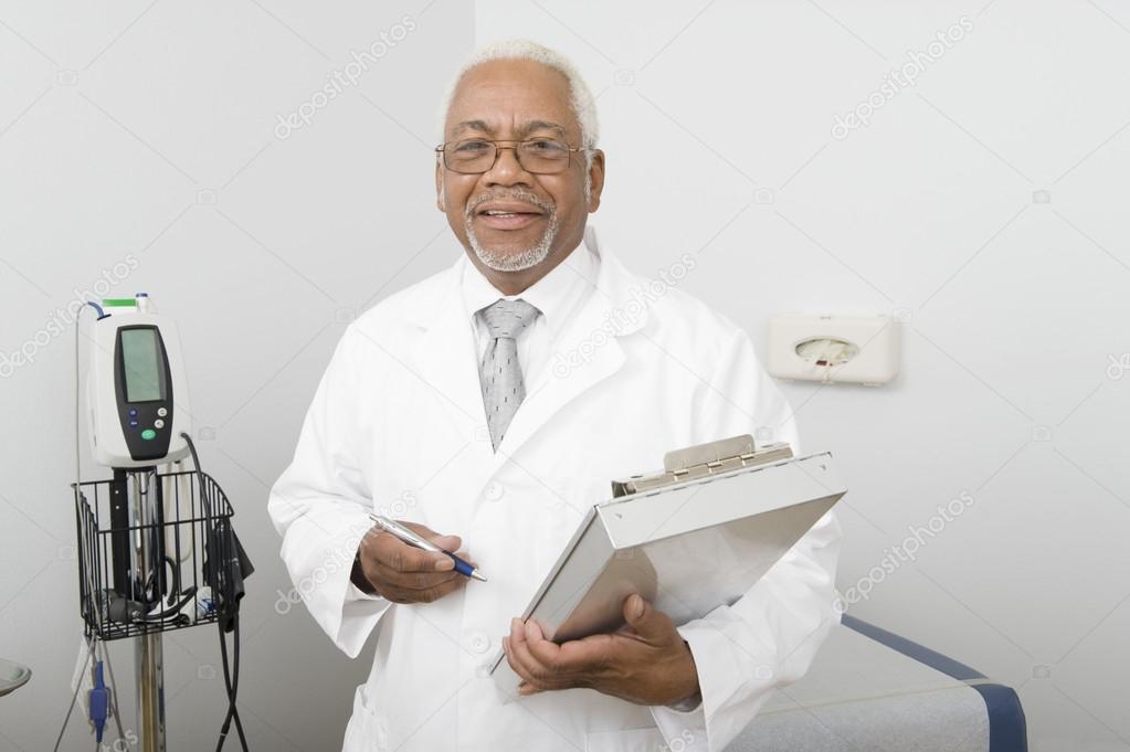 Male Doctor Holding Clipboard At Clinic
