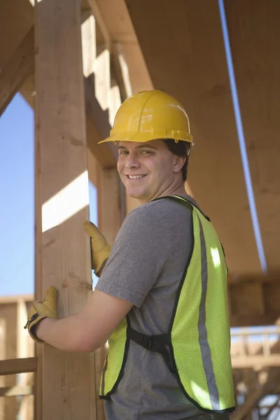 Arbeiter positioniert Planke aus Holz — Stockfoto