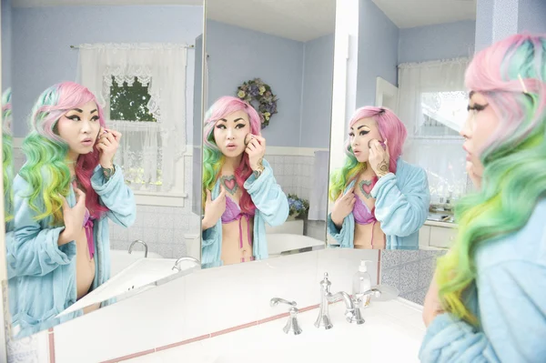 Young woman applying makeup with multiple mirror reflections — Stock Photo, Image