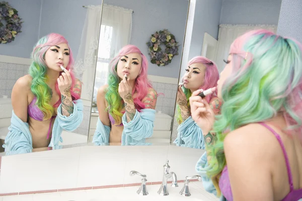 Young woman applying lipstick on her lips with multiple mirror reflections — Stock Photo, Image