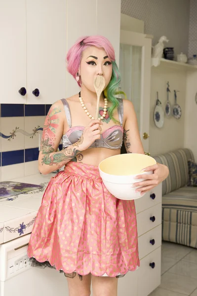 Portrait of a young woman with wooden spoon on mouth — Stock Photo, Image