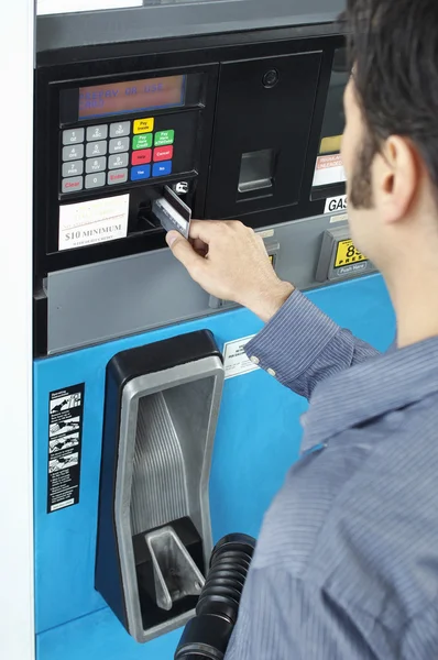 Mand betaler med kreditkort på brændstof pumpe - Stock-foto