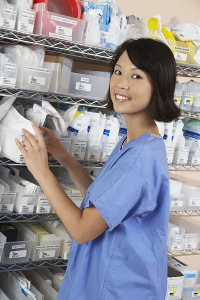 Farmacéutica femenina de pie junto al estante — Foto de Stock