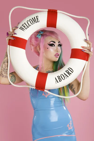 Young woman holding float tube over pink background — Stock Photo, Image