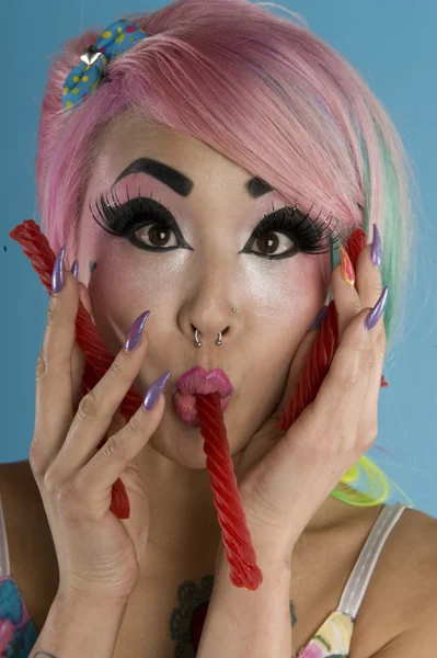 Portrait of young woman holding candy cane in her mouth — Stock Photo, Image