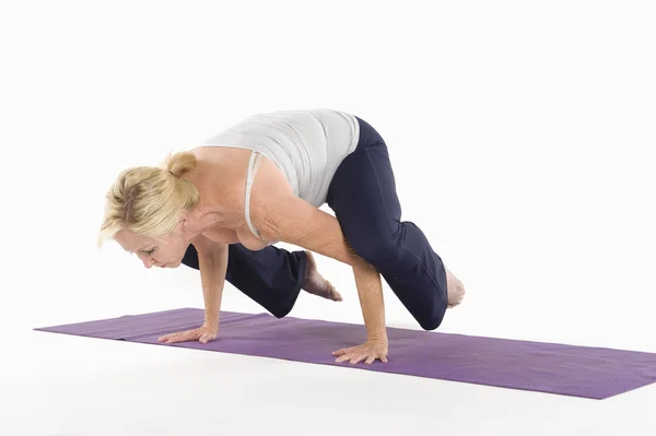 Madura mujer equilibrio en sus manos —  Fotos de Stock