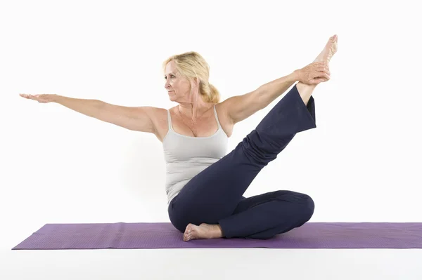 Mujer de mediana edad haciendo yoga sobre fondo blanco — Foto de Stock