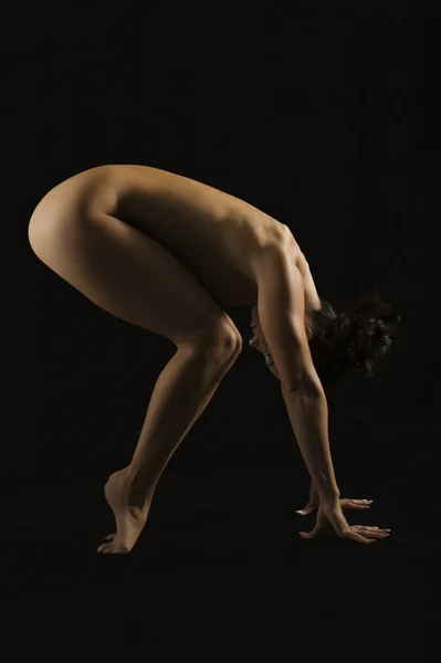 Sidan profil av en naken kvinna som utövar — Stockfoto