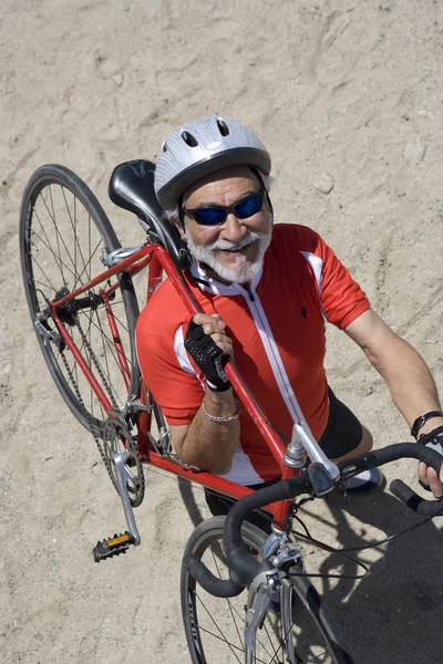 Homem sênior carregando bicicleta em seu ombro — Fotografia de Stock