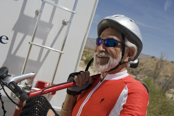 Hombre cargando bicicleta en su hombro y mirando hacia otro lado — Foto de Stock