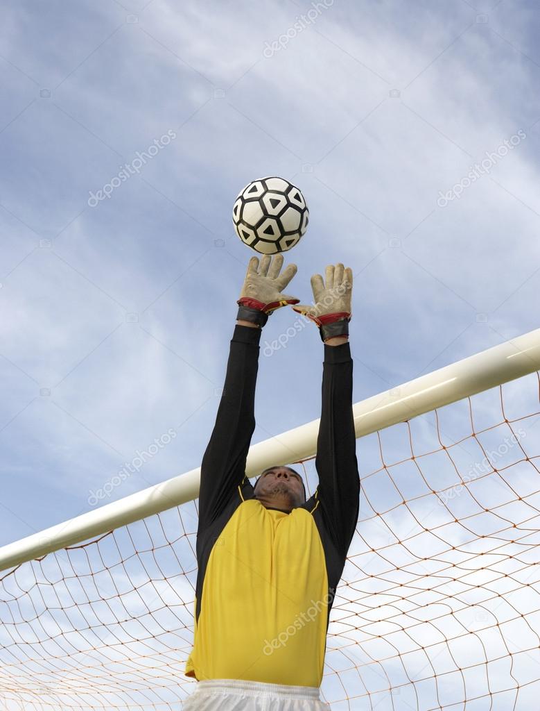 Goalkeeper Jumping To Catch The Ball