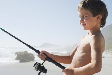 jongen vissen op strand