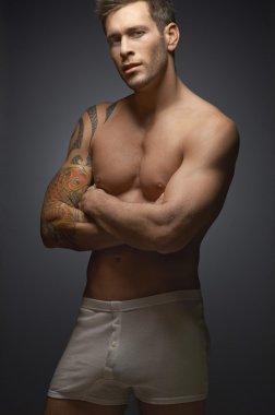 gömleksiz adam ayakta kollarını çapraz