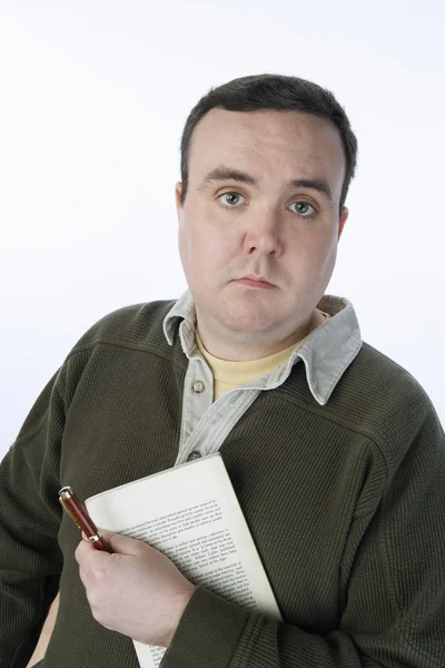Мужчина средних лет с книгой и ручкой — стоковое фото
