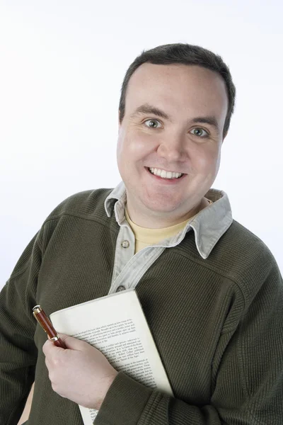 Среднего возраста мужчина держит ручку и книгу — стоковое фото