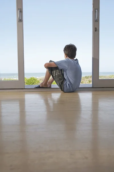 Chłopiec siedzi w drzwiach — Zdjęcie stockowe