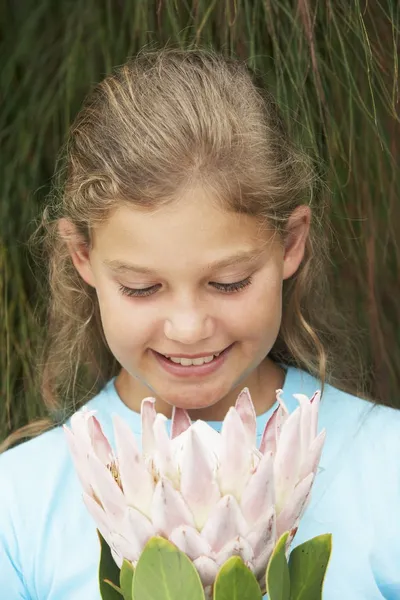 Flickan tittar på färsk blomma — Stockfoto