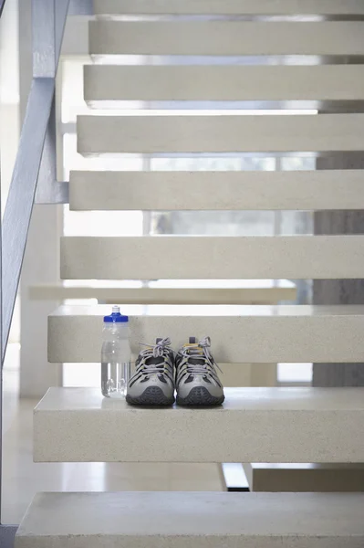 Sapatos de esportes e garrafa de água nas escadas — Fotografia de Stock