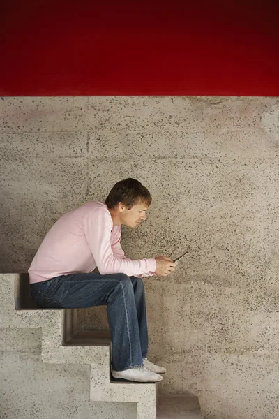 Hombre usando el teléfono celular en las escaleras — Foto de Stock