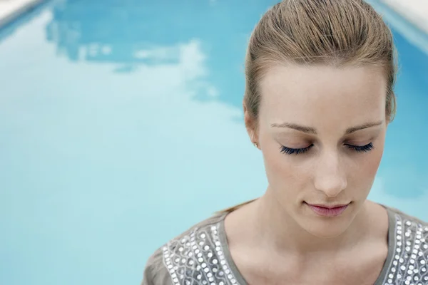 Ontspannen jonge vrouw bij zwembad — Stockfoto