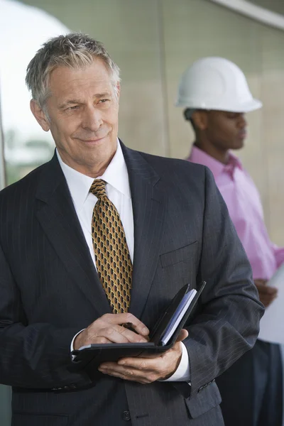 Businessman Holding Dairy With Male Architect — Stock Photo, Image