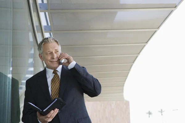 Businessman With Day Planner While On Call — Stock Photo, Image