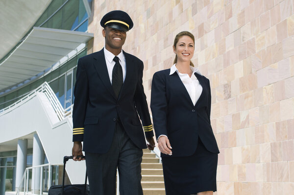 Pilot And Flight Attendant Walking Outside Building