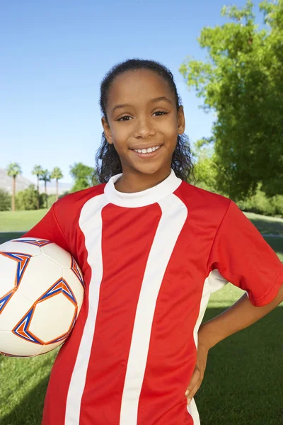 Девушка, стоящая с футбольным мячом — стоковое фото